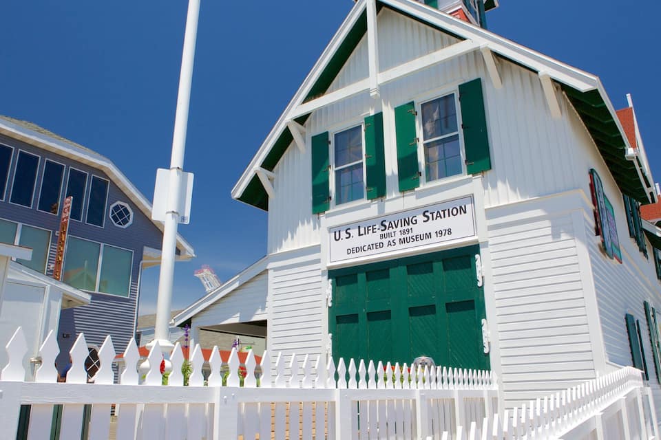 A U.S. Life-Saving Station building with a white exterior and green shutters.