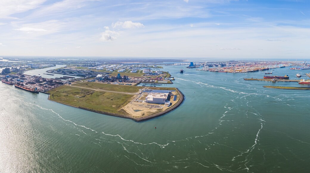 Aerial shot over harbor area, industrial landscape, oil storage containers and tanker ships, blue sky in the background, Maasvlakte, Netherlands. High quality photo