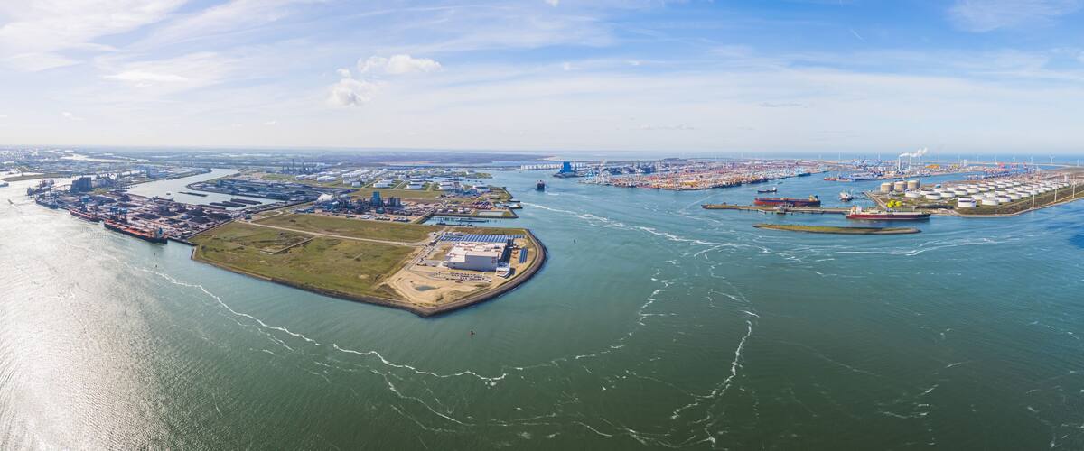 An aerial view of a port with multiple docks, ships, and industrial facilities.