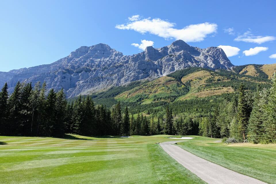 Un campo de golf con montañas al fondo.
