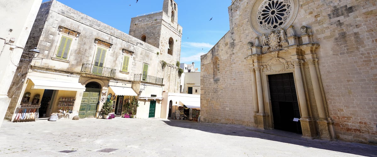 A historic square with a church, a tower, and a market area.