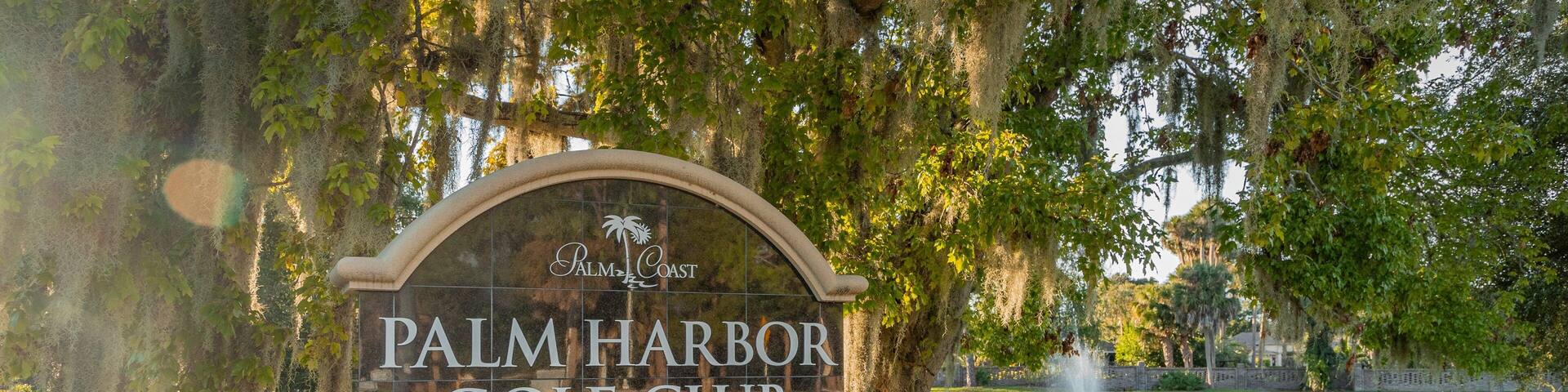 Palm Harbor Golf Club showing a pond and signage