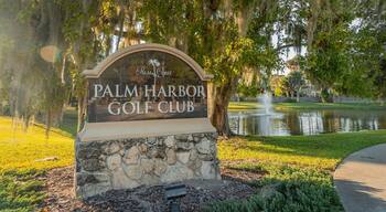 Palm Harbor Golf Club showing a pond and signage