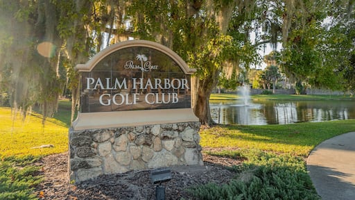 Palm Harbor Golf Club showing a pond and signage