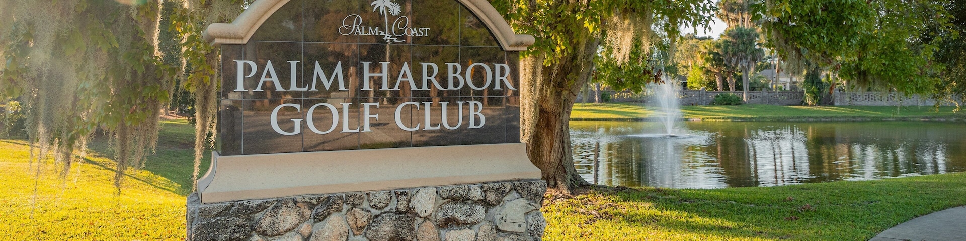 Palm Harbor Golf Club showing a pond and signage