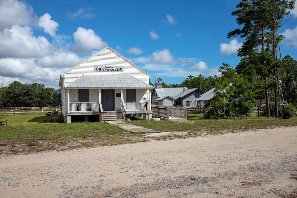 A white wooden building labeled "Traxler Commissary" with a porch and a small staircase.