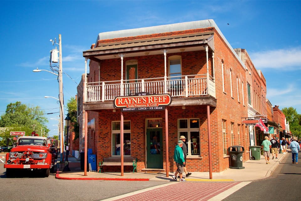 A brick building with a balcony and a sign reading "Rayne's Reef" with a soda fountain and grill.