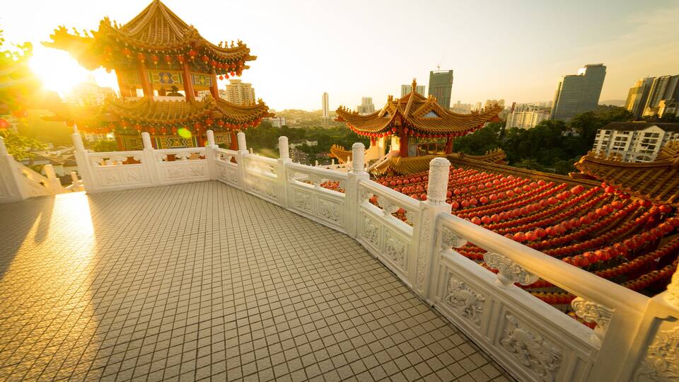 A traditional Chinese pavilion with ornate roofs and red lanterns, surrounded by a tiled walkway and a white fence.
