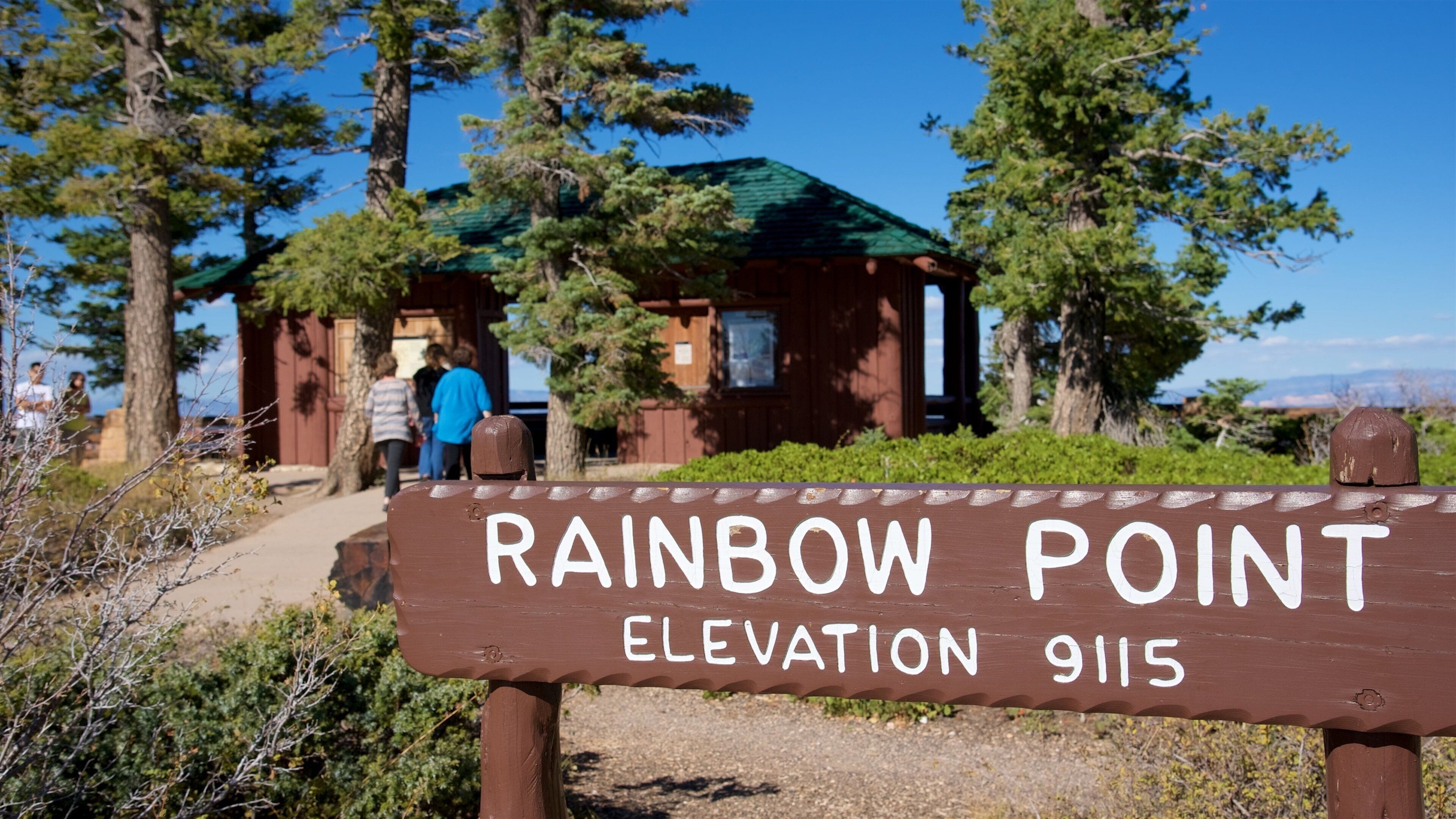 Rainbow Point featuring tranquil scenes and signage as well as a small group of people