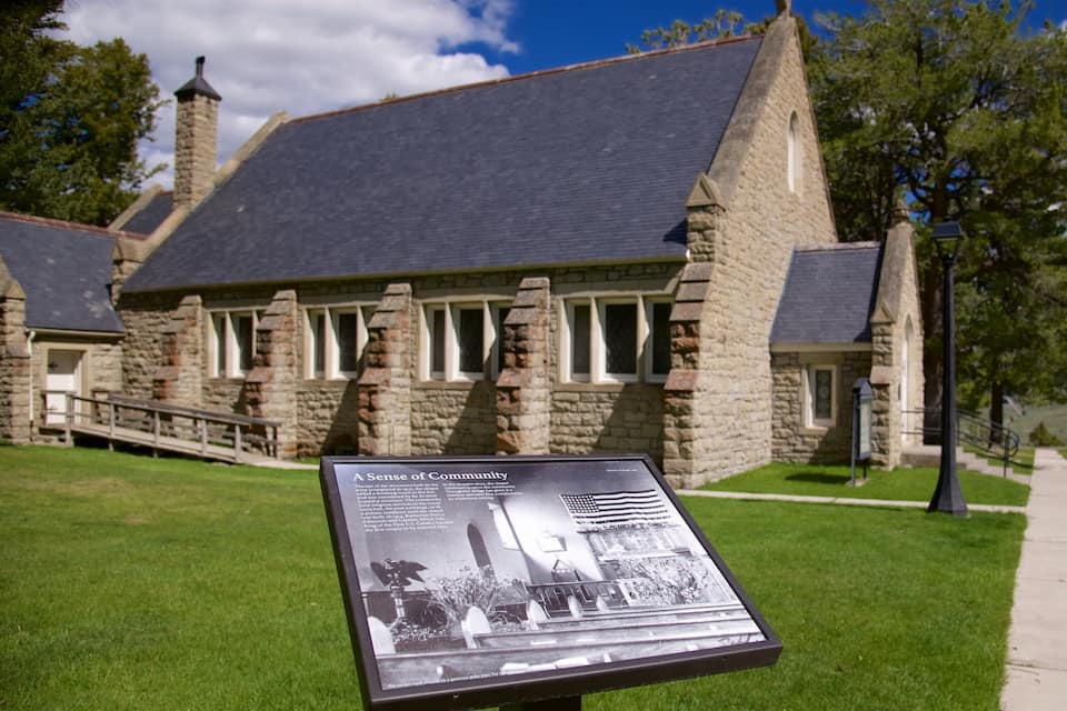 A stone building with a sign in front.