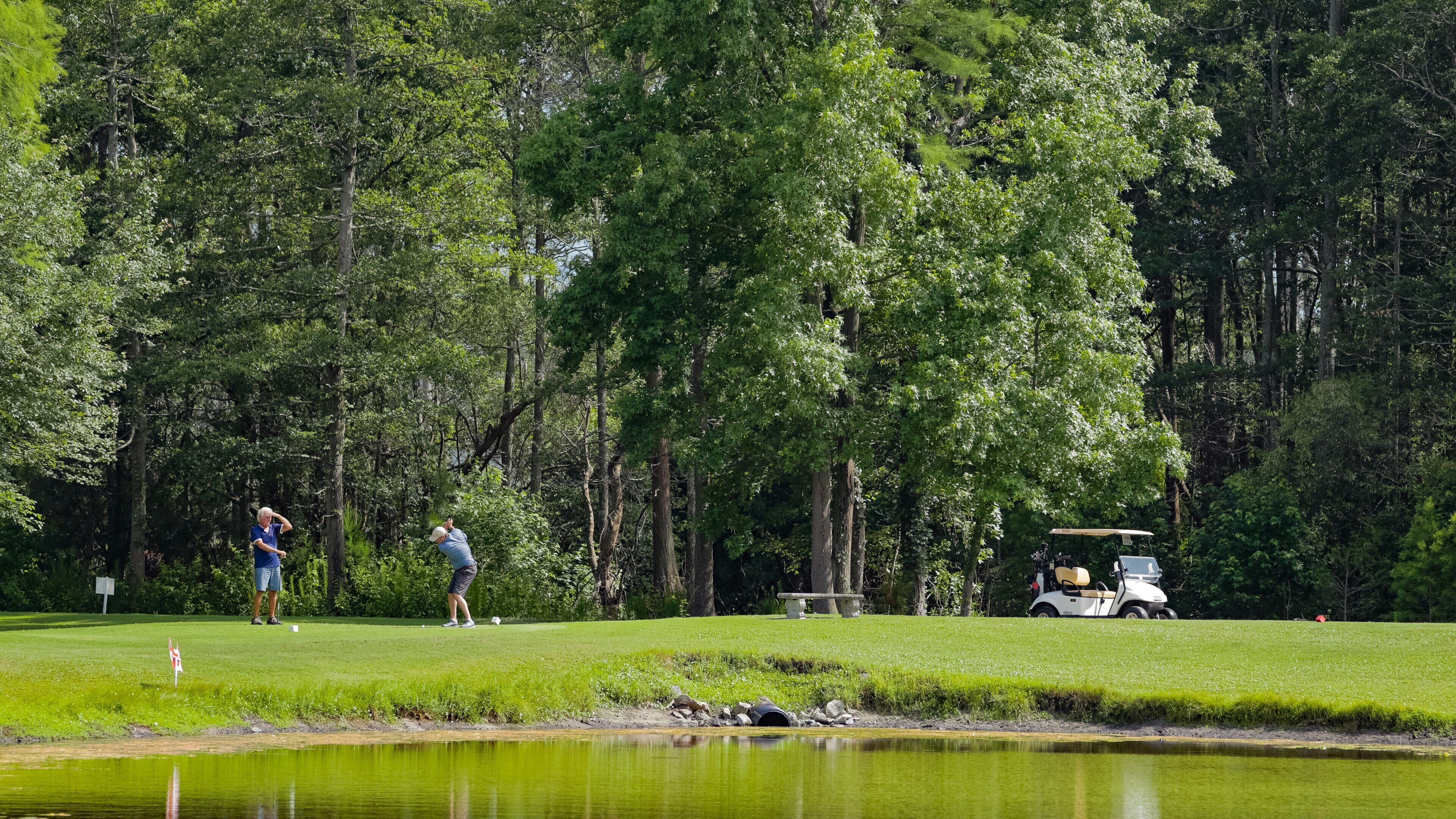Tupelo Bay Golf Center featuring golf and a pond as well as a couple