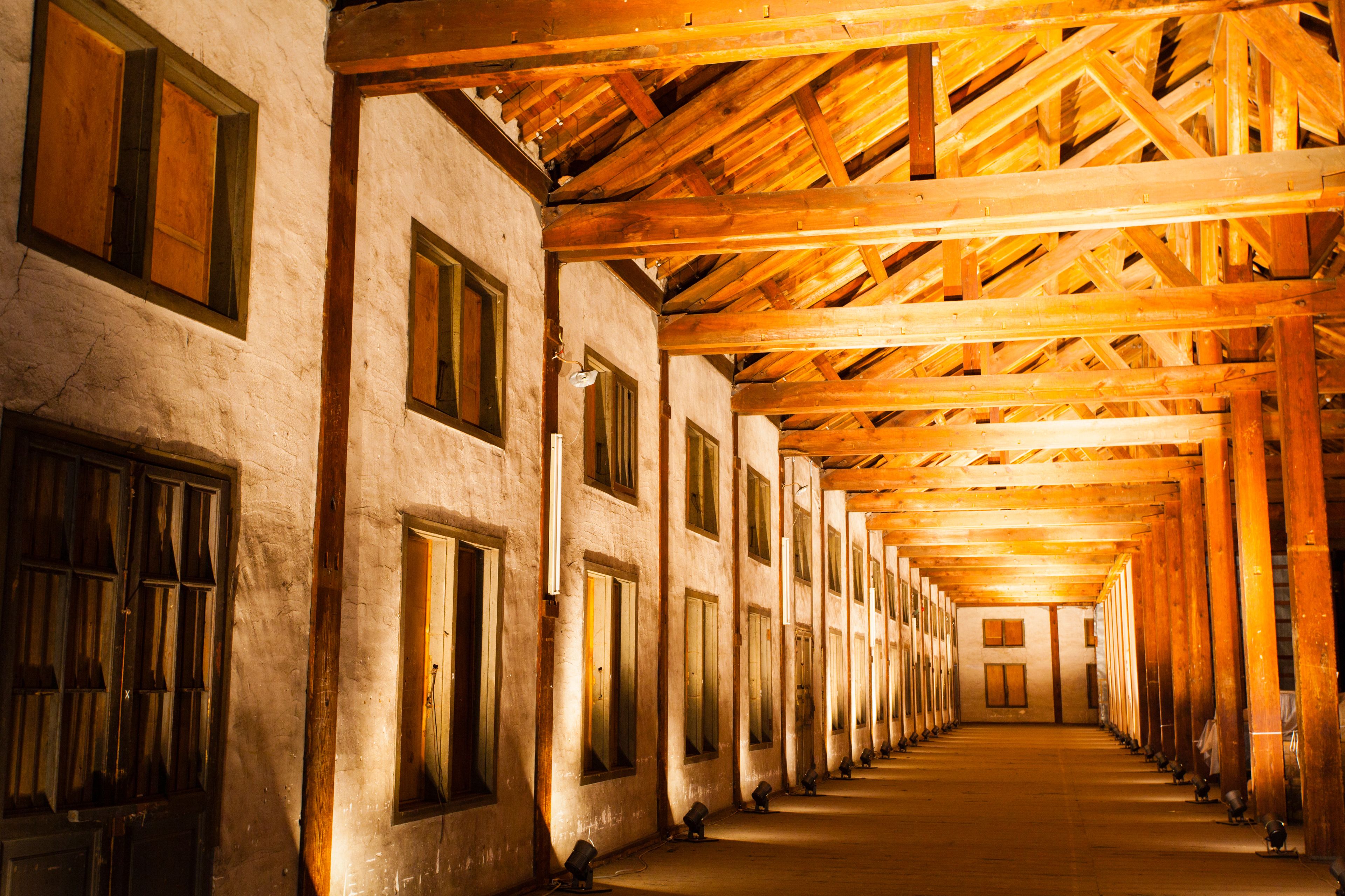 A long corridor with wooden beams and large windows.