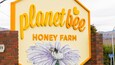 Schild für Planet Bee Honey Farm mit einer Illustration einer Biene.