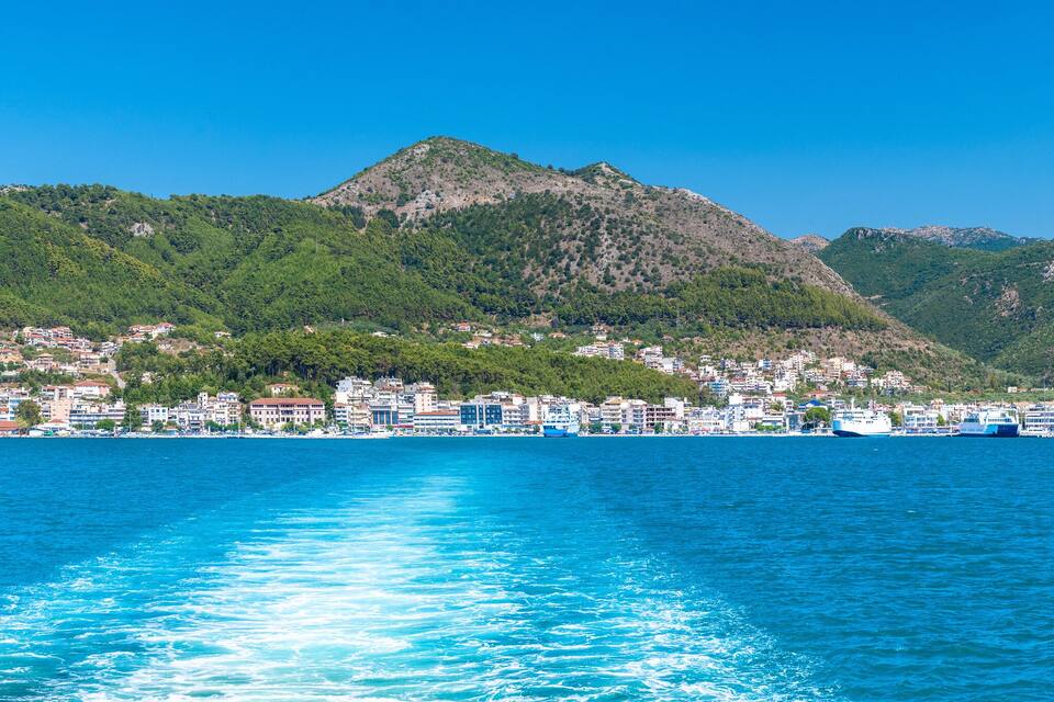 A coastal city with a mountainous backdrop and a clear blue sea.