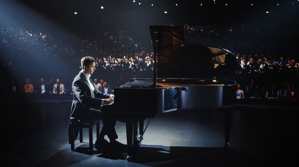 Cinematic Portrait of a Music Artist Performing on Stage, His Hands Moving Effortlessly Over the Grand Piano. Sophisticated Crowd Watching as He Brings Each Dramatic and Emotional Composition to Life