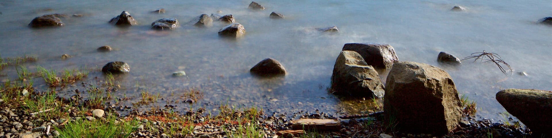 Sproat Lake Petroglyphs ofreciendo una playa de guijarros y un lago o abrevadero