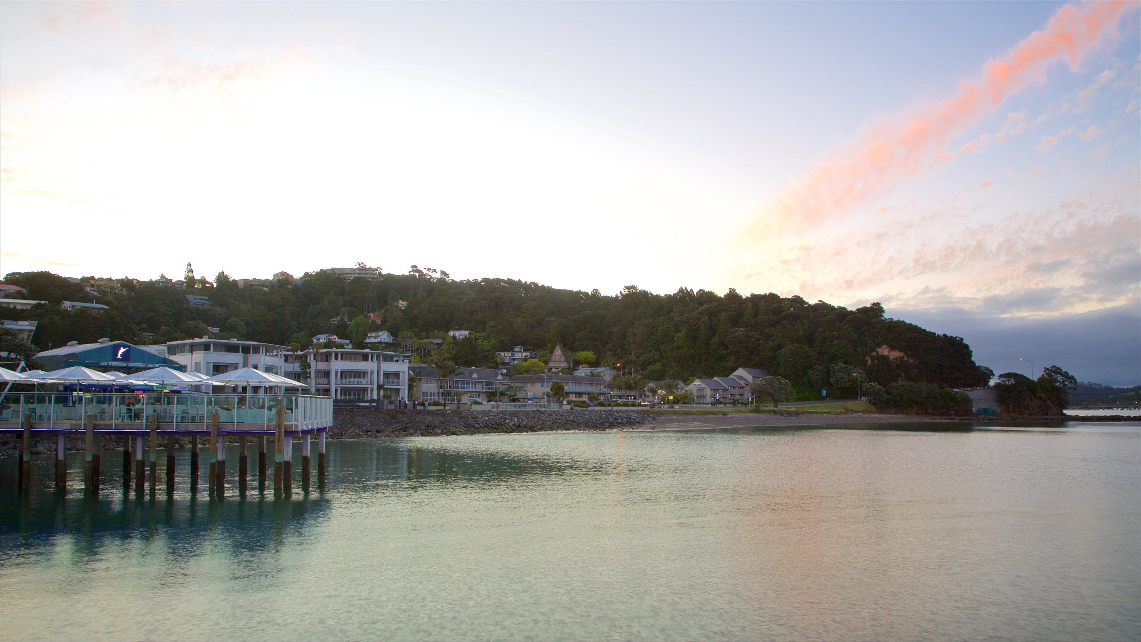 Paihia brygge som viser solnedgang, kystby og bukt eller havn