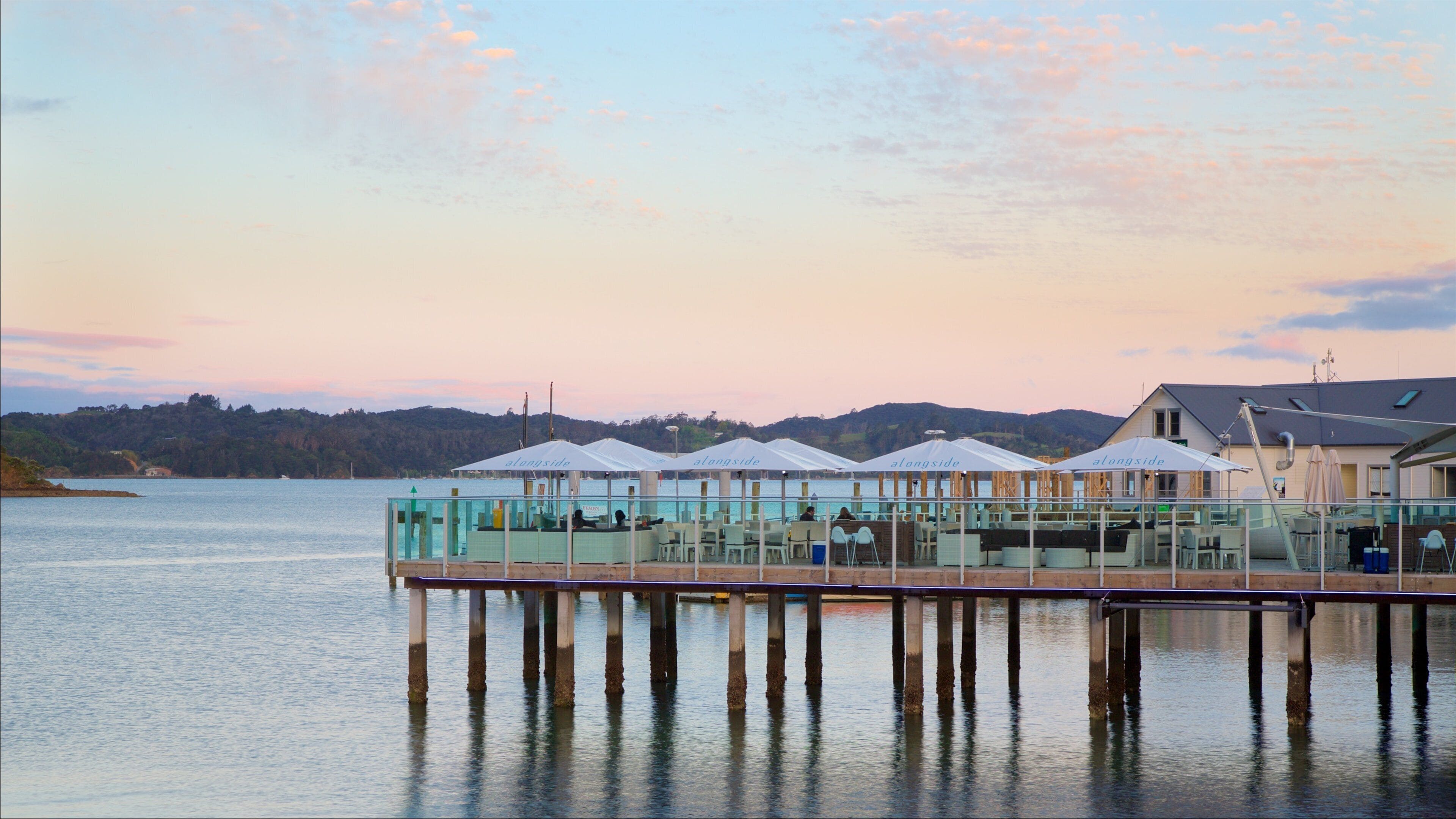 Paihia brygge som viser kafé, bukt eller havn og solnedgang
