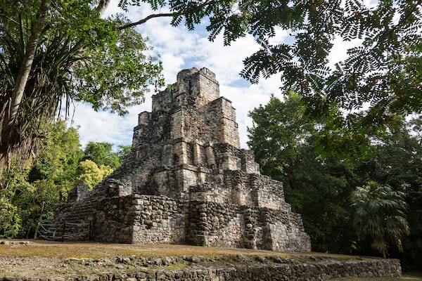 Une pyramide de pierre antique, entourée d’une végétation luxuriante.