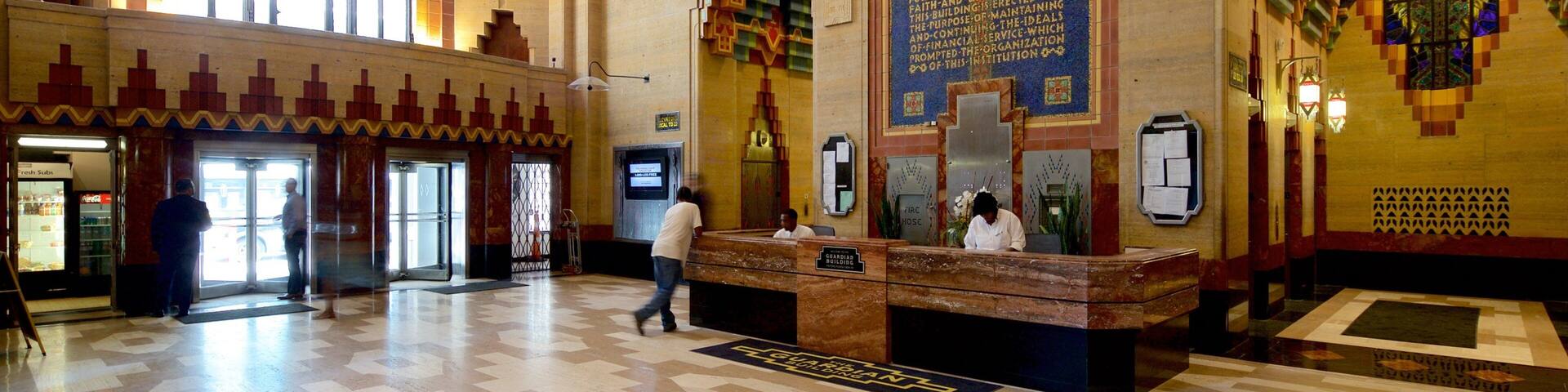 A lobby with a large arched window, a reception desk, and colorful geometric wall patterns.