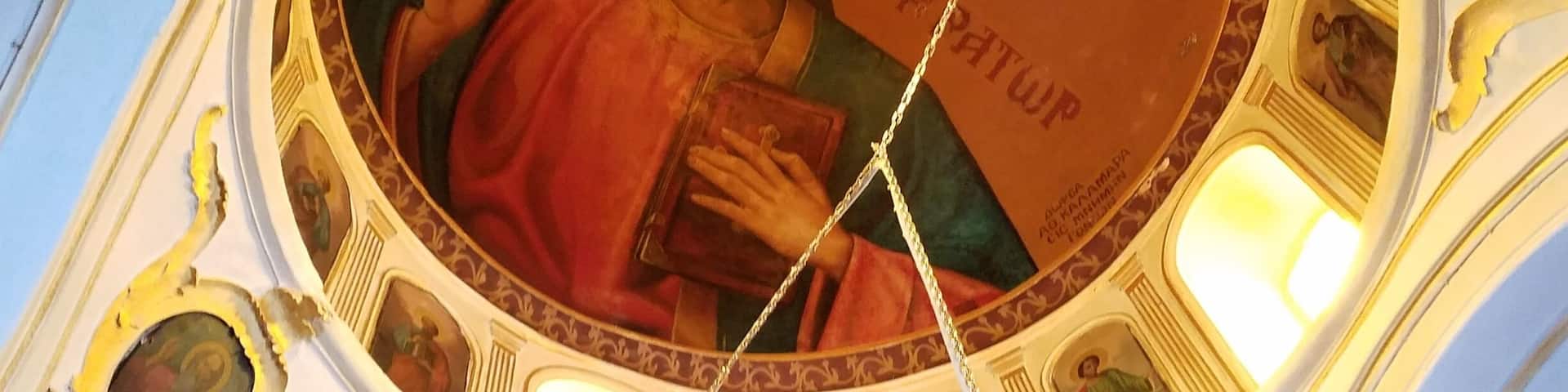 A fresco of a religious figure holding a book, surrounded by ornate architectural details and smaller figures.