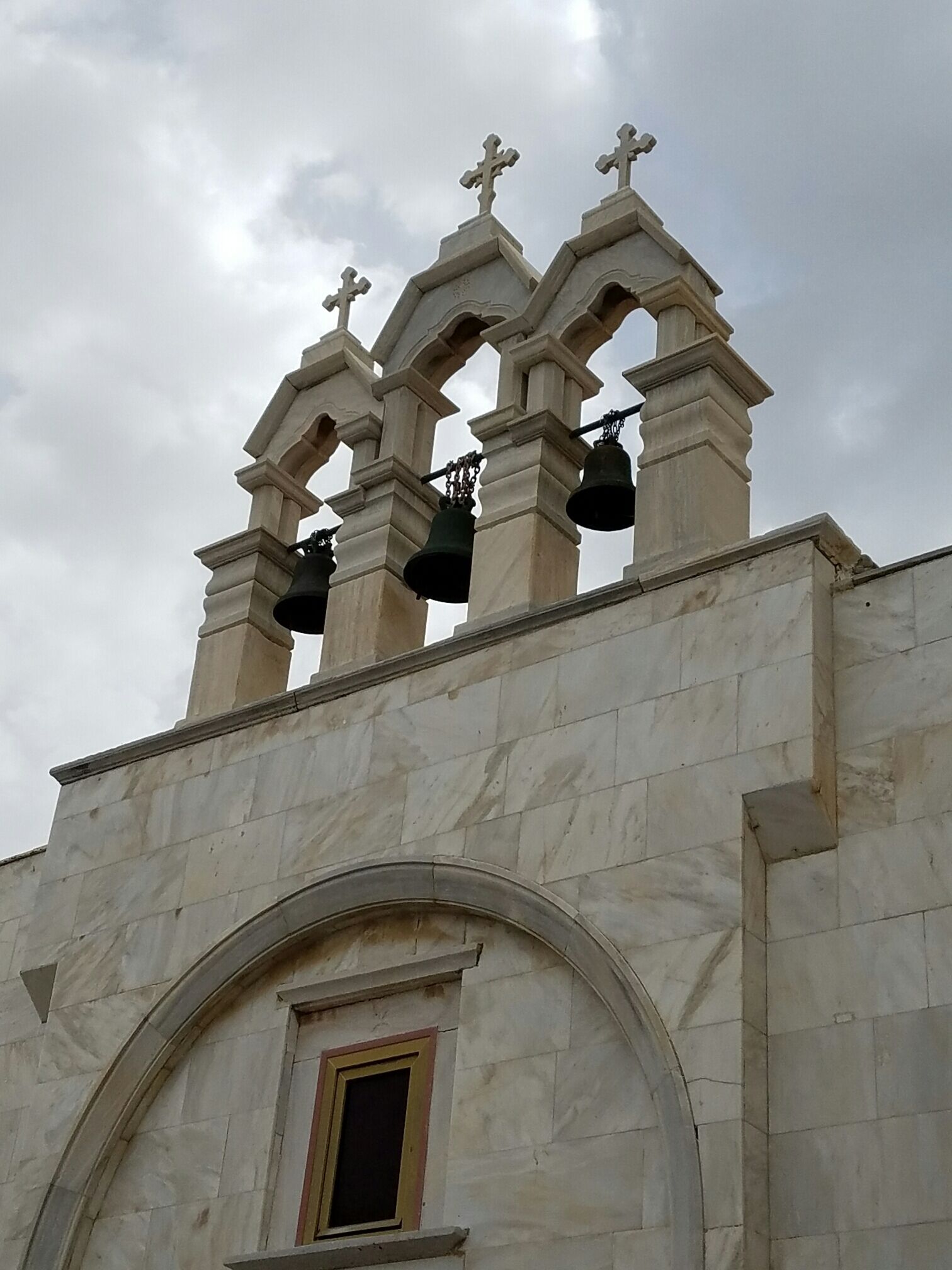 A church with three crosses and a bell tower.