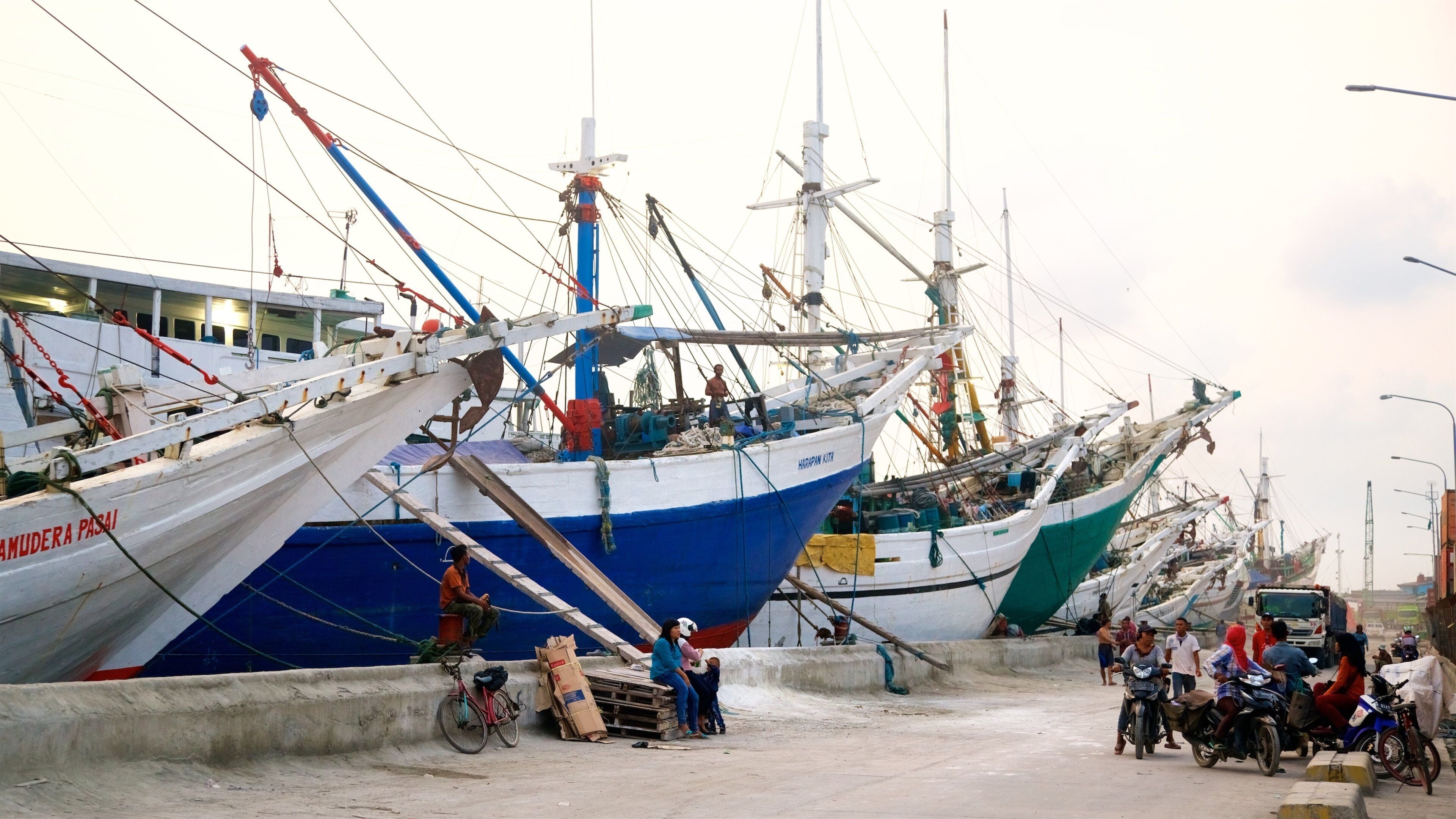 A harbor with several large fishing boats docked.