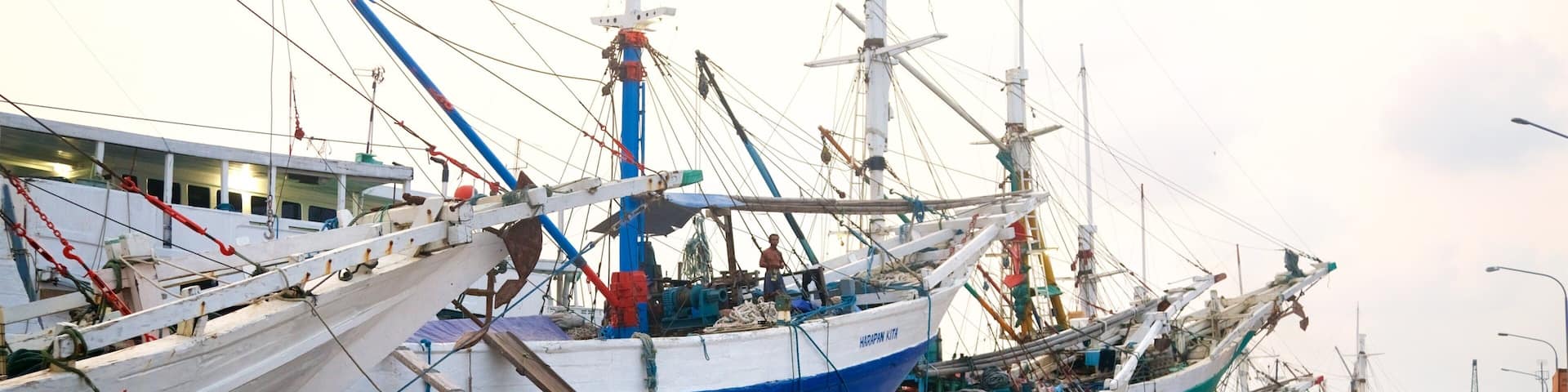 A harbor with several large fishing boats docked.
