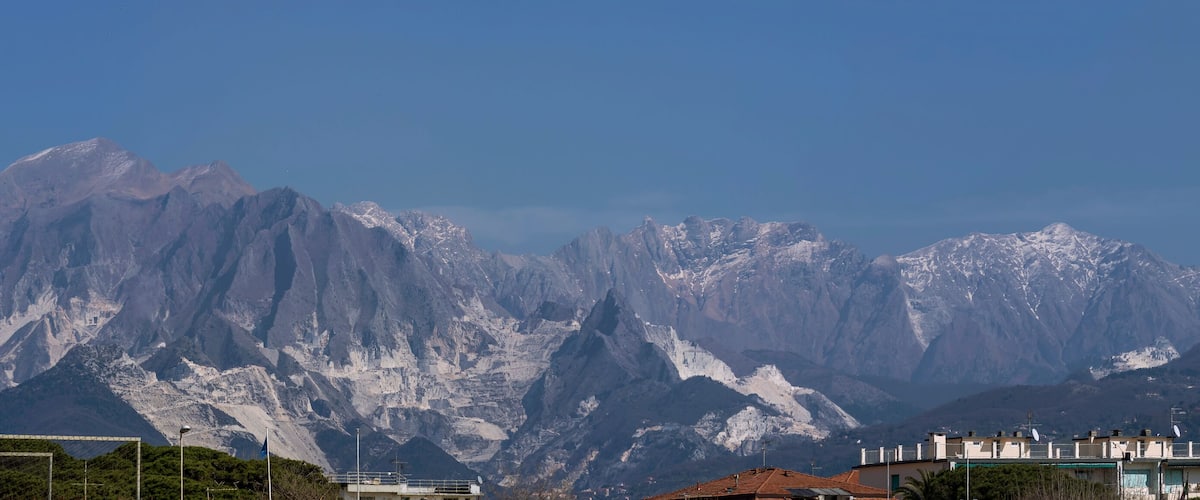 A mountain range with snow-capped peaks and a clear blue sky.