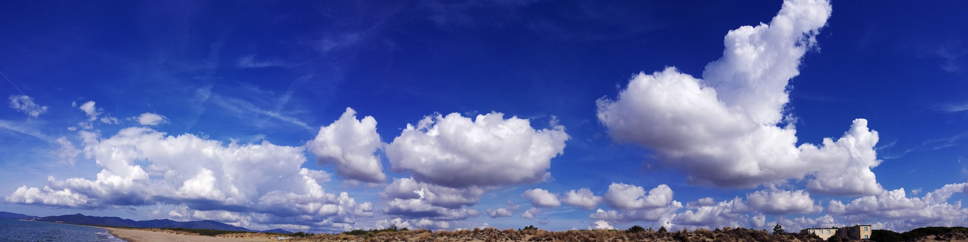 Italy, Tuscany, Maremma, Marina di Grosseto panoramic photo from the beach, in the background the port and castle of Castiglione della Pescaia.