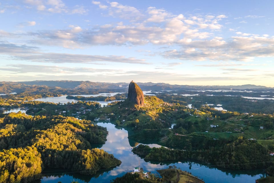 Ett bergigt landskap med en markant klippformation, en flod och spridda bebyggelseområden.