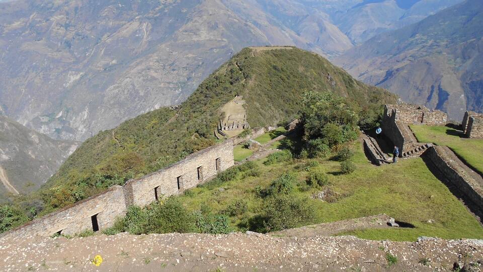 A mountainous landscape with ancient stone structures and a clear sky.