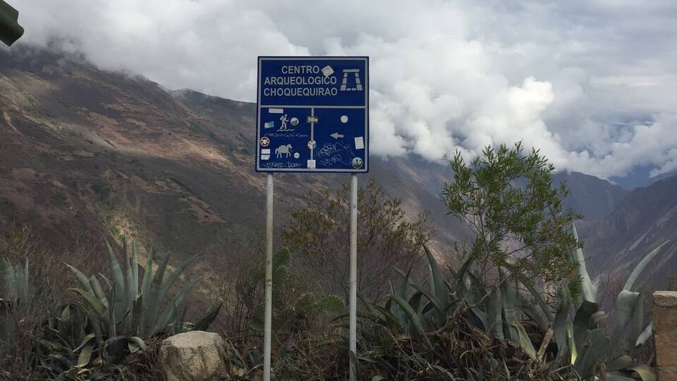 A sign for Centro Arqueologico Chooquequirao with symbols for facilities and directions.
