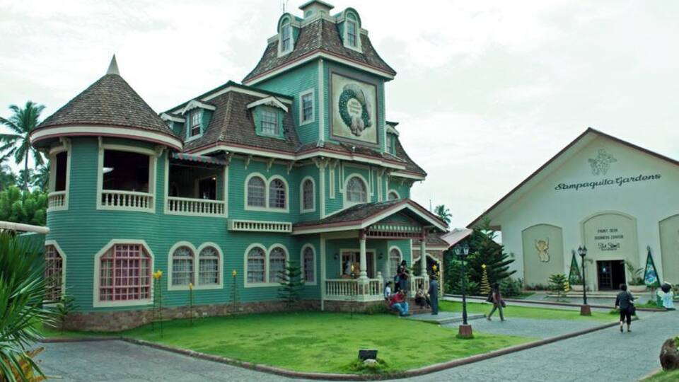 A large, ornate building with a green facade and a clock tower.