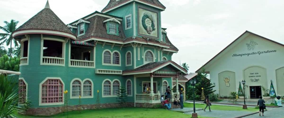 A large, ornate building with a green facade and a clock tower.