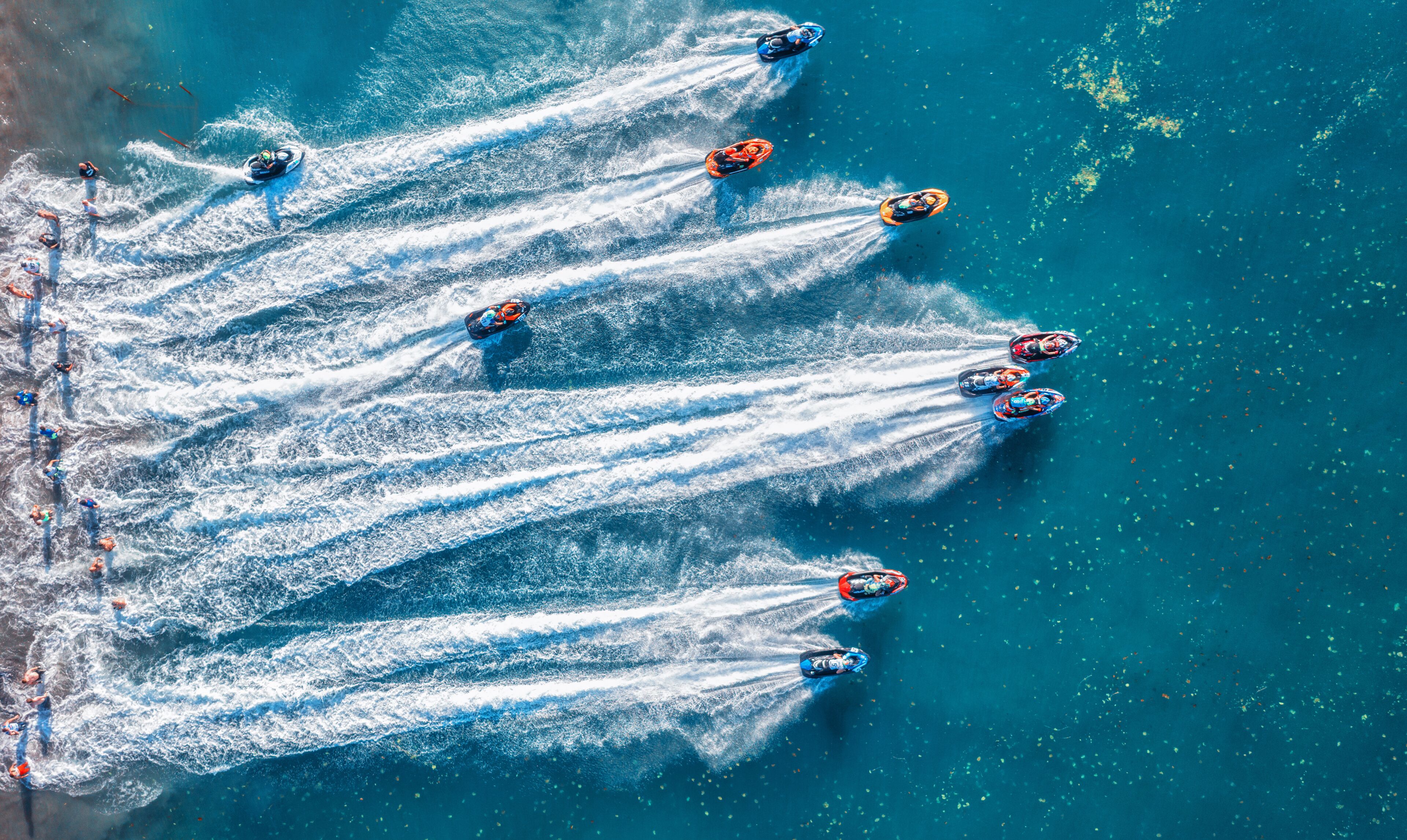 Un grupo de lanchas rápidas generan olas en el agua.