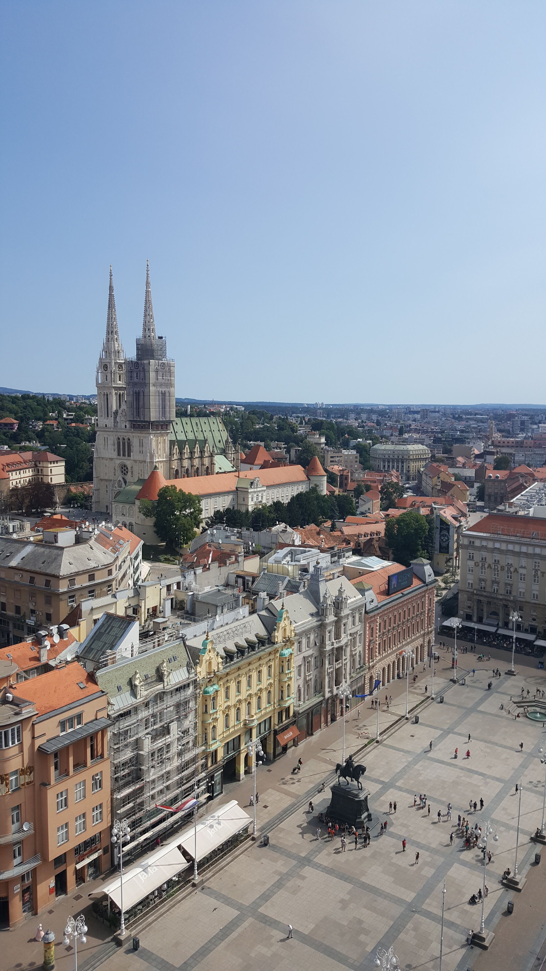 Une vue urbaine mettant en valeur une cathédrale imposante, une place centrale et des bâtiments historiques environnants.