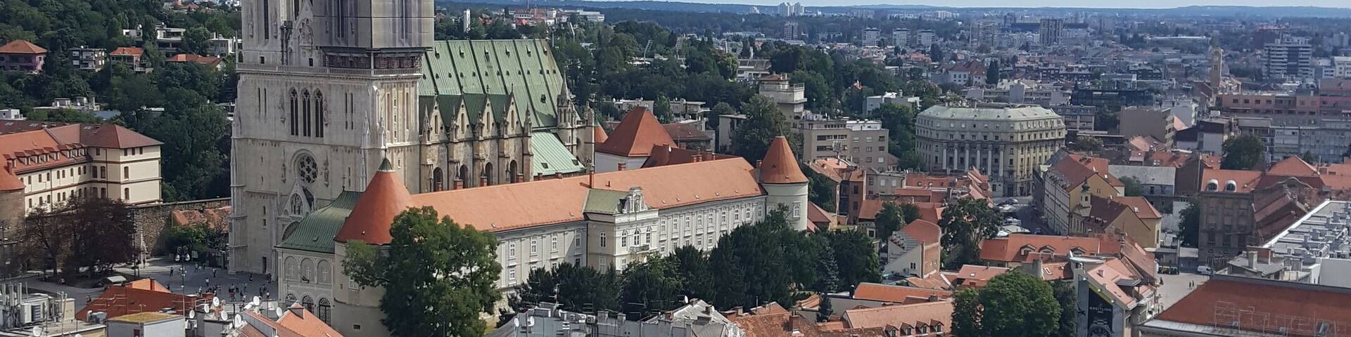 A cityscape with a prominent cathedral, a central square, and surrounding historic buildings.
