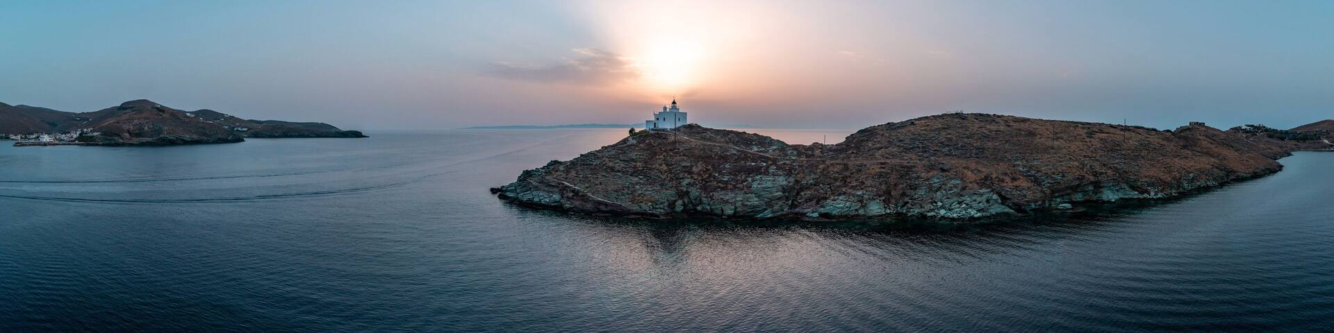 Greece, Kea Tzia island. Lighthouse on rocky cape, sky, sea background.