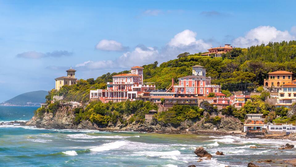 A coastal town with buildings on a hillside overlooking the sea.