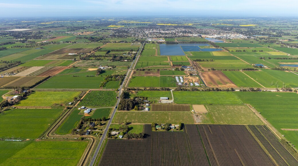 Aerial view of beautiful patchwork farmland and tranquil wetlands under a blue sky, Kyabram, Australia.