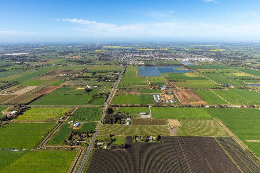 Aerial view of beautiful patchwork farmland and tranquil wetlands under a blue sky, Kyabram, Australia.