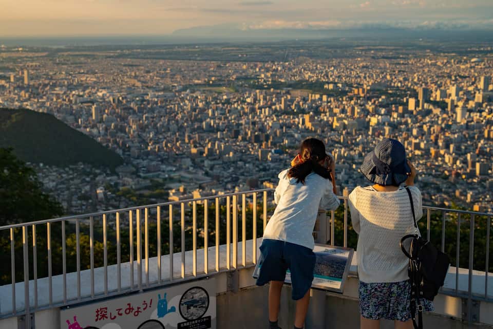Dos personas observando un paisaje urbano desde un lugar elevado.