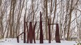 A metal sculpture in a snowy forest.
