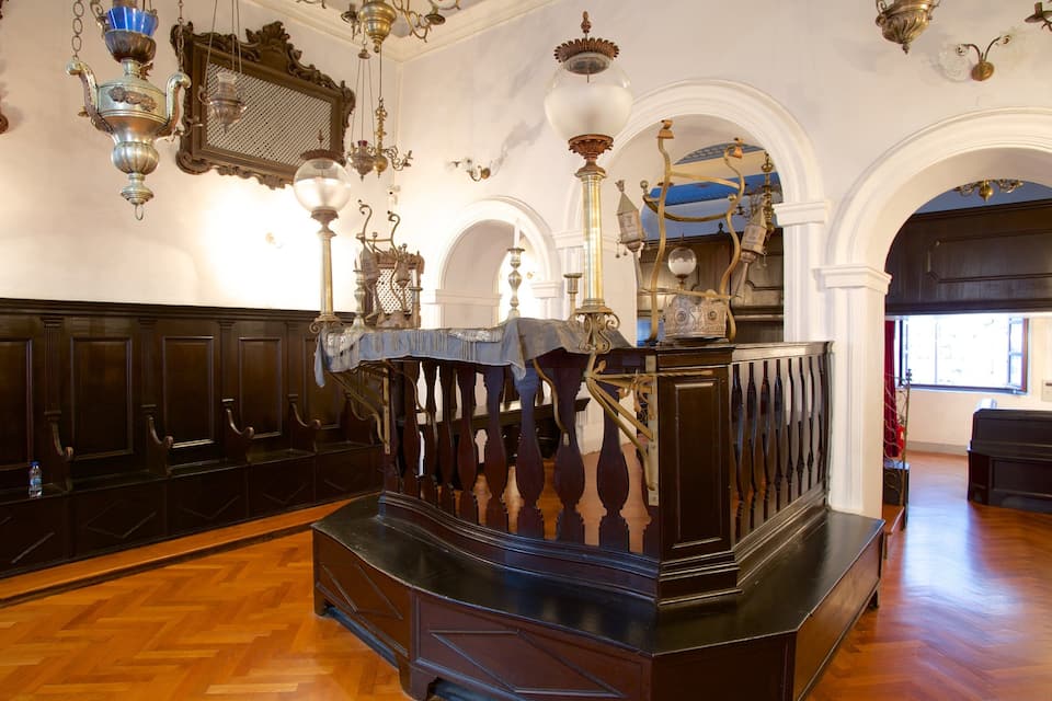 Una habitación ornamentada con un órgano de madera, candelabros y un espejo.