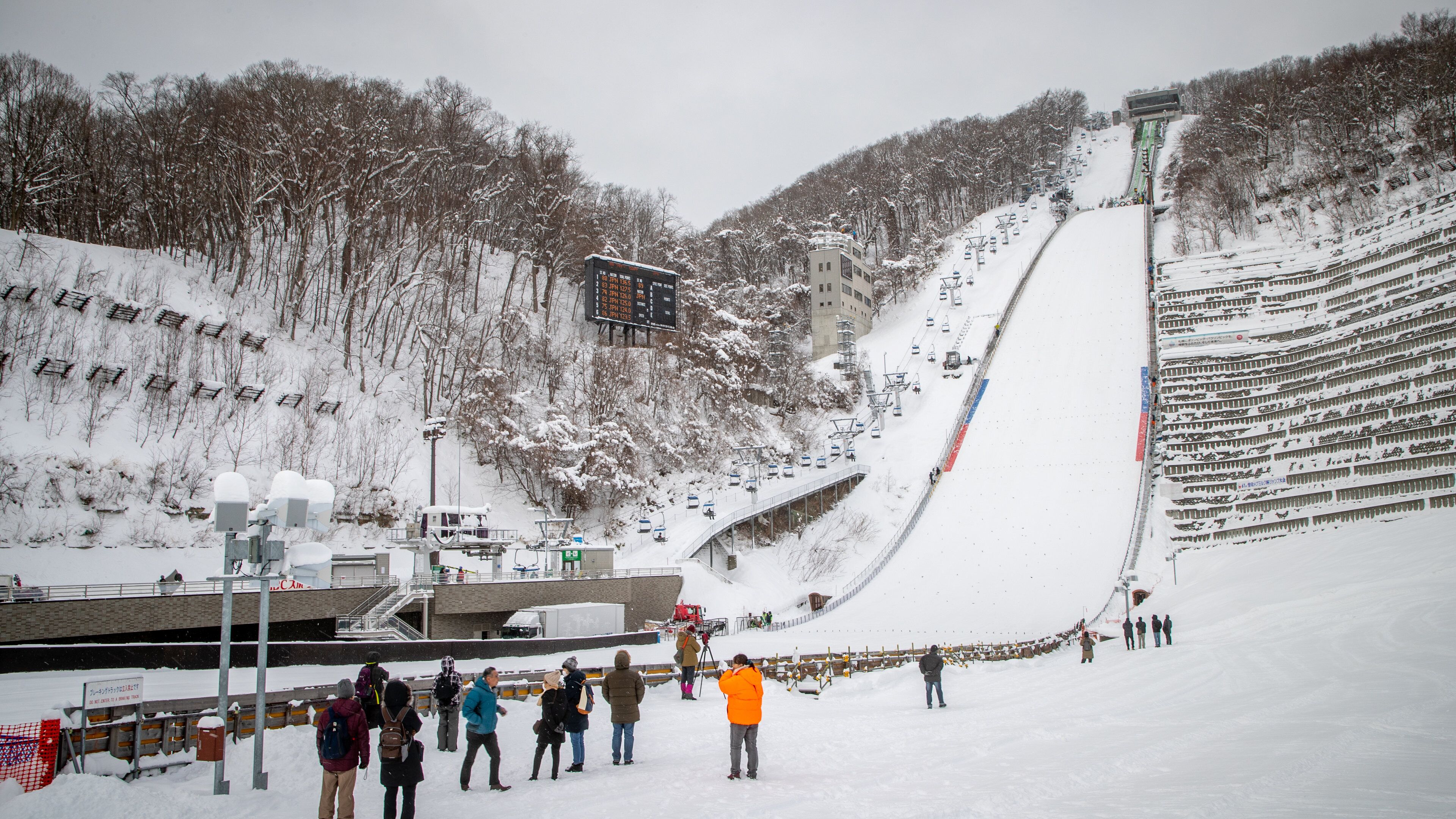 Sapporo Winter Sports Museum showing snow and mountains as well as a small group of people