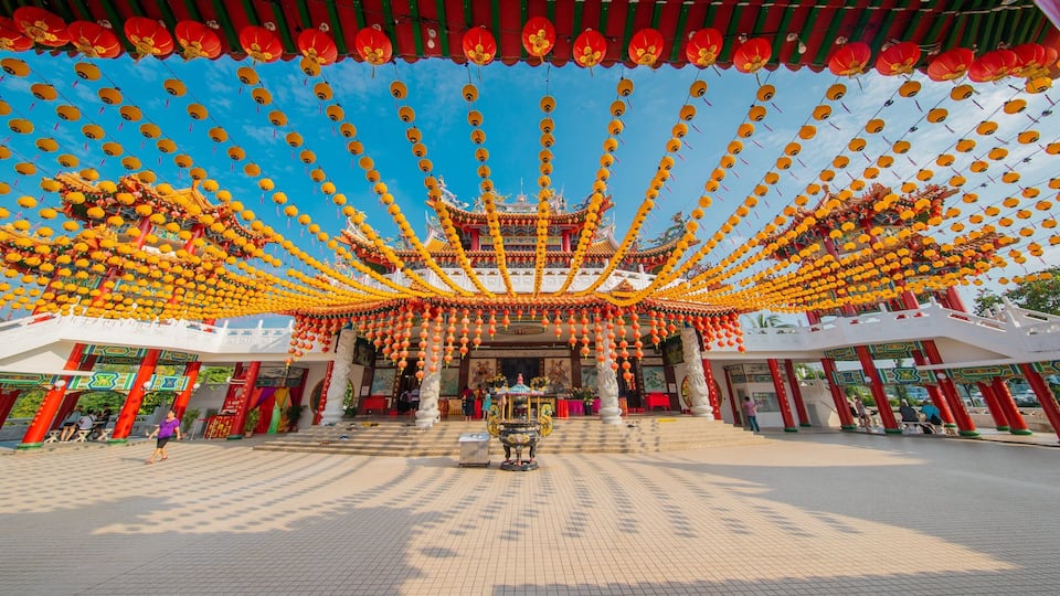 A traditional Chinese temple with ornate architecture, red and yellow lanterns, and a tiled courtyard.