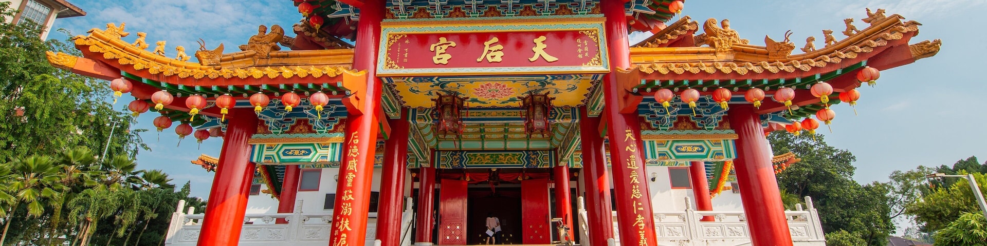 Un portón chino tradicional con pilares rojos y adornos elaborados.