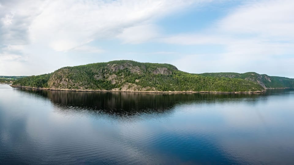 A calm lake with a forested island in the center.