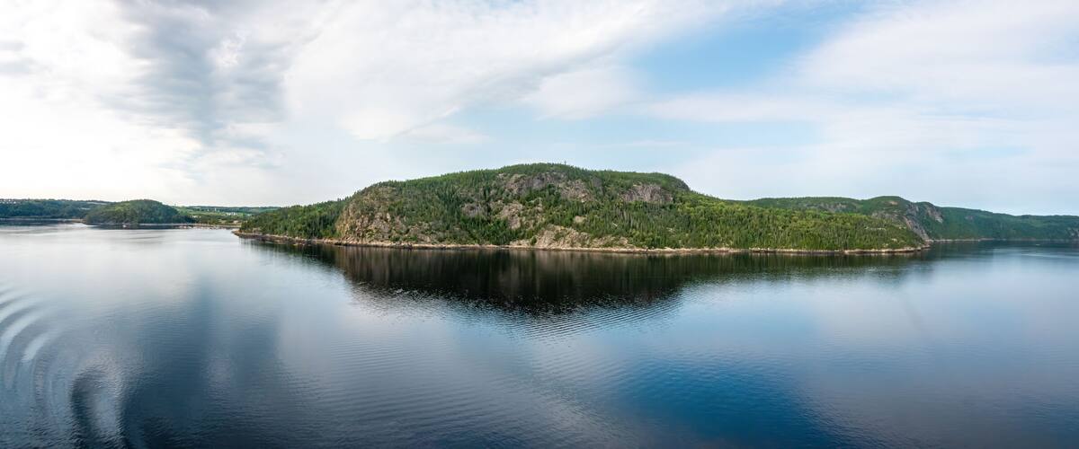 A calm lake with a forested island in the center.